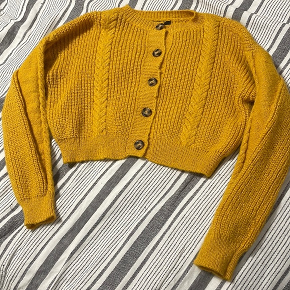The color of the cardigan is yellow with buttons down the middle. - Picture 1 of 7